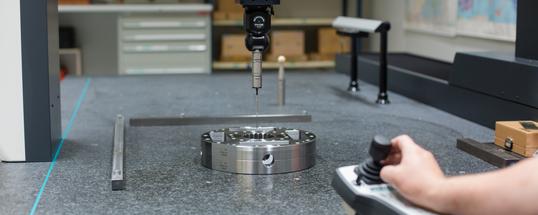 Werknemer controleert product op de 3D meetmachine